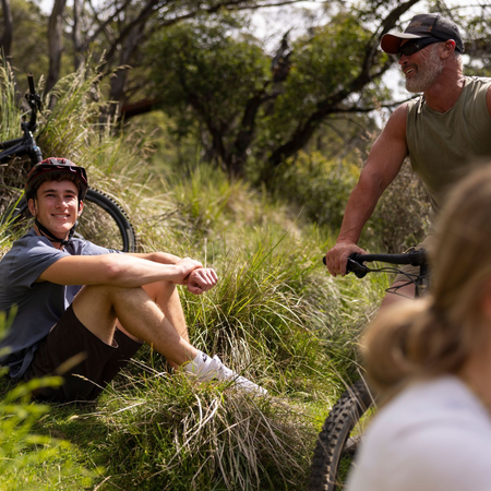 A family enjoys  thrill of moutain bike riding at the Thredbo Valley Track, Thredbo, Snowy Mountains