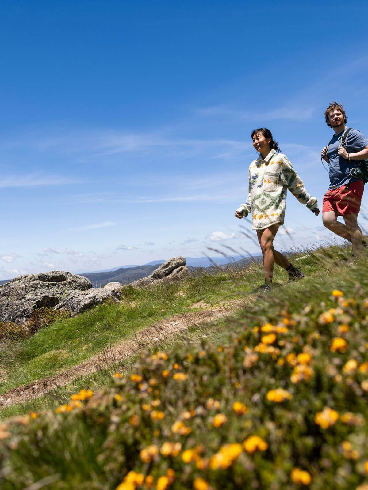 A couple takes in the amazing views hiking along the Thredbo Mountain Bike Park, Snowy Mountains
