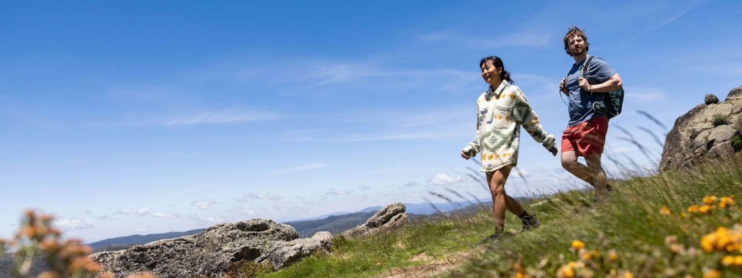 A couple takes in the amazing views hiking along the Thredbo Mountain Bike Park, Snowy Mountains