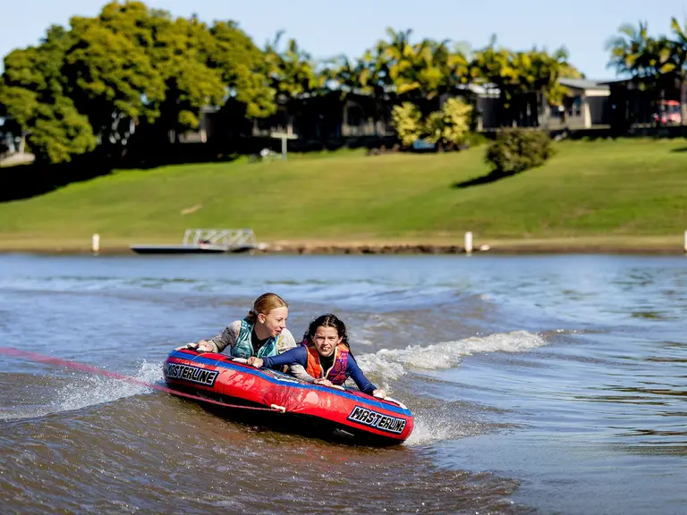 Two young girls enjoying a ride on the Clarence River at BIG4 Big River Holiday Park near Grafton, NSW.