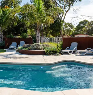 Lagoon style swimming pool surrounded by landscaped gardens at Geelong Holiday Park.