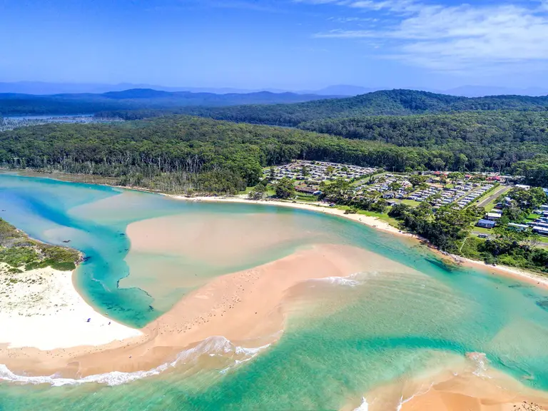Aerial view of Durras Inlet and Joalah Holiday Park, surrounded by the coastal bushland of Murramarang National Park on the NSW South Coast.