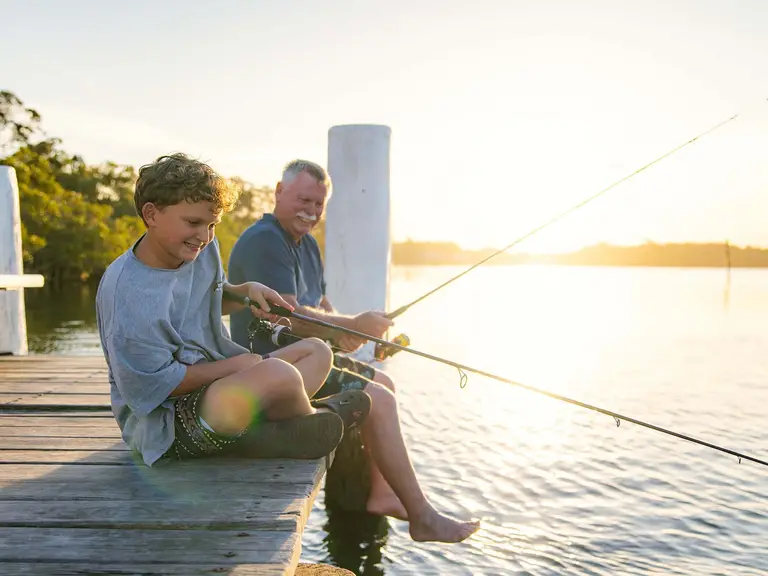 Father and son fishing together from a jetty on the Manning River on the NSW Mid North Coast.