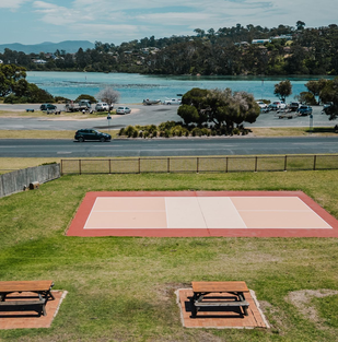 Merimbula motel: outdoor recreation area with games court and seating overlooking the water