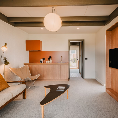Merimbula motels: renovated suite at Black Dolphin Motel featuring a lounge area, kitchenette and mid-century-inspired interiors