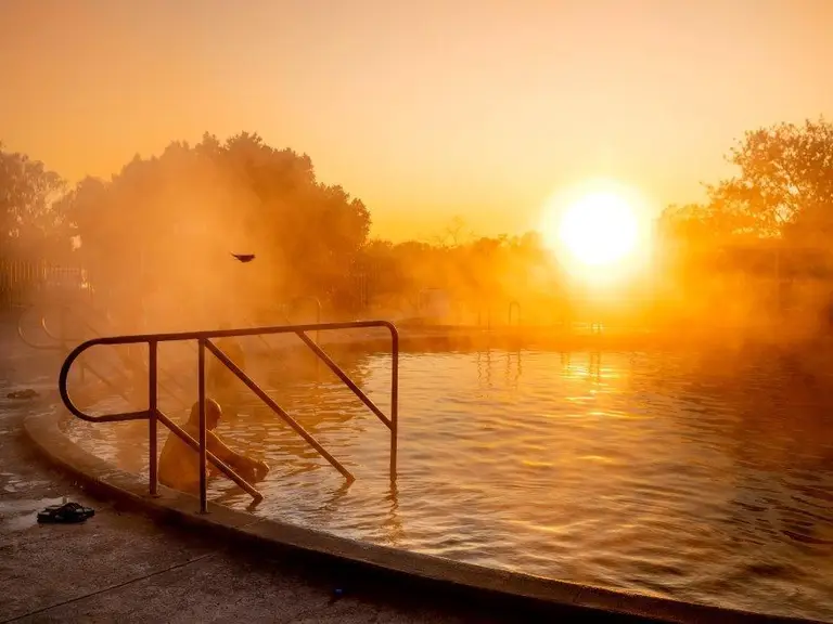Visitors relaxing in the naturally heated artesian bore baths at night in Lightning Ridge, NSW.