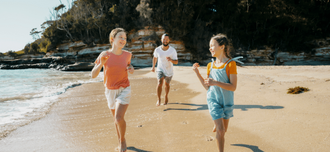 Family running along the beach at Durras Beach, NSW